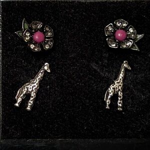Two pair of earrings: Silver giraffe earrings, and purple flowers. New
